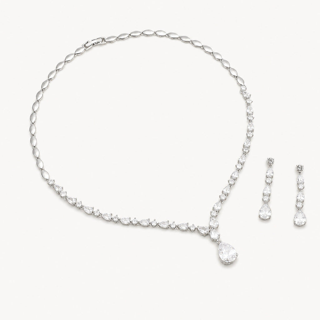 The Elodie Pear-Drop Necklace & Earrings Set on a warm white background