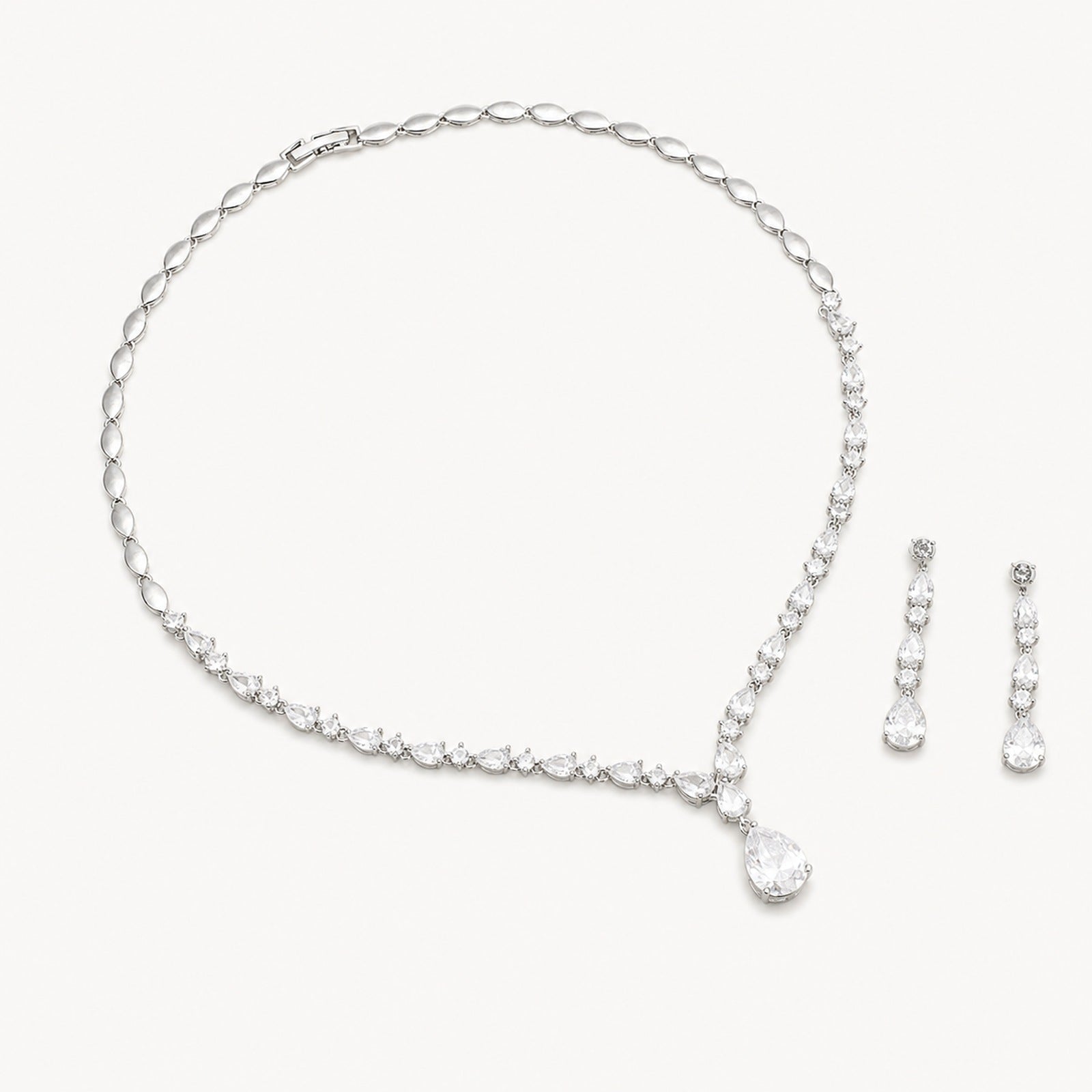 The Elodie Pear-Drop Necklace & Earrings Set on a warm white background
