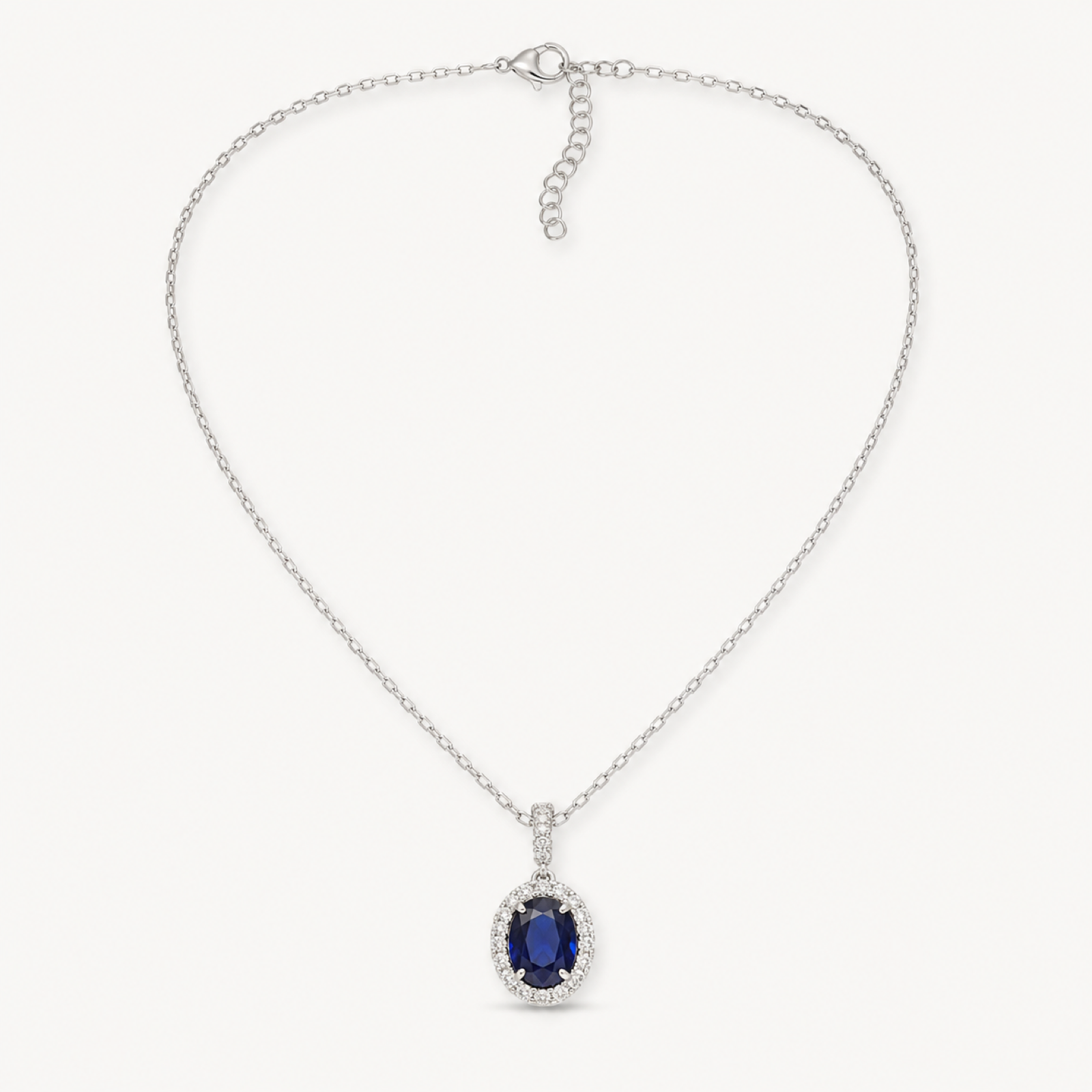 Isolde royal blue oval halo pendant necklace on warm white